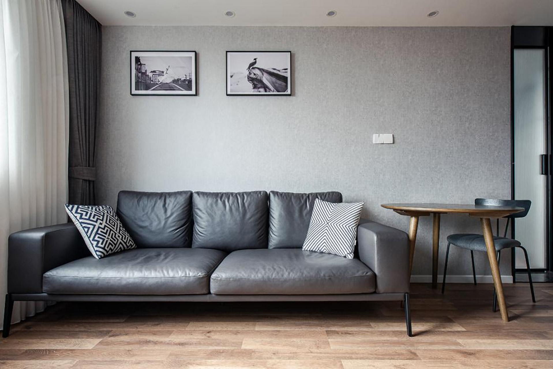 沙发背景墙的墙纸选用了颜色更深的纹理,深灰皮质沙发,深灰窗帘白纱